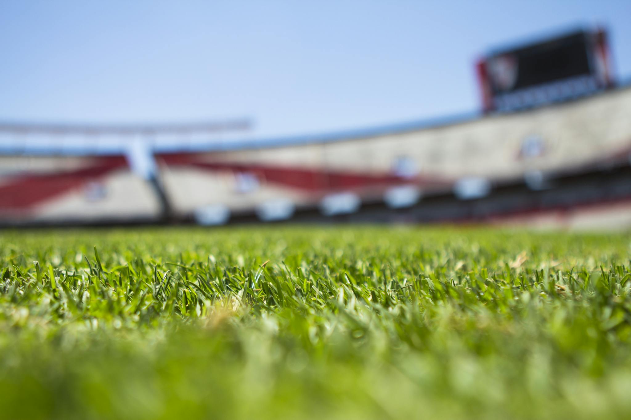 Green Grass Across Beige Red Open Sports Stadium during Daytime